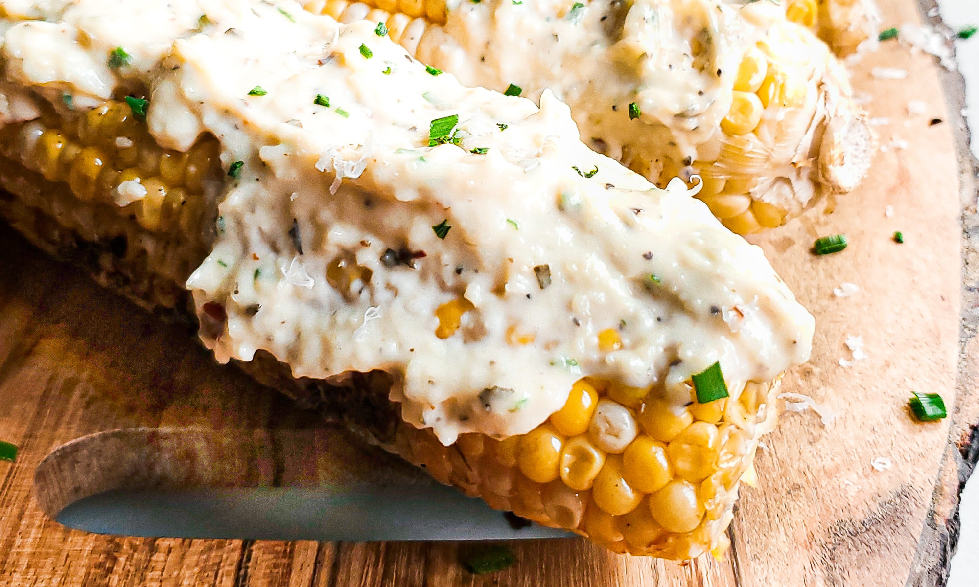 Grilled corn on a platter with garlic parmesan sauce
