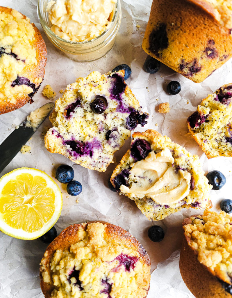 Overhead shot of blueberry lemon poppyseed corn muffins with a smear of vanilla honey butter